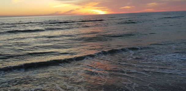 バルト海のビーチ、海辺、夏の夜に日没時に海岸線.  - 写真・画像