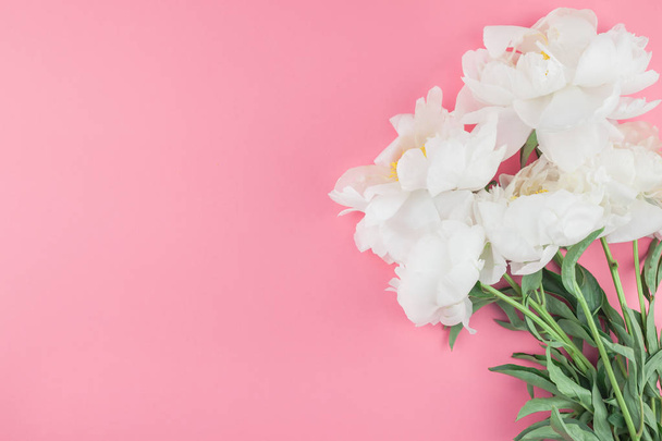 Virágzó fehér bazsarózsa virágok a minimál stílus, sablon, képeslap, a betűk, a szöveg másolása szóközzel pasztell színű papír alapon a design. Esküvői meghívó és ünnepi köszöntő koncepció - Fotó, kép
