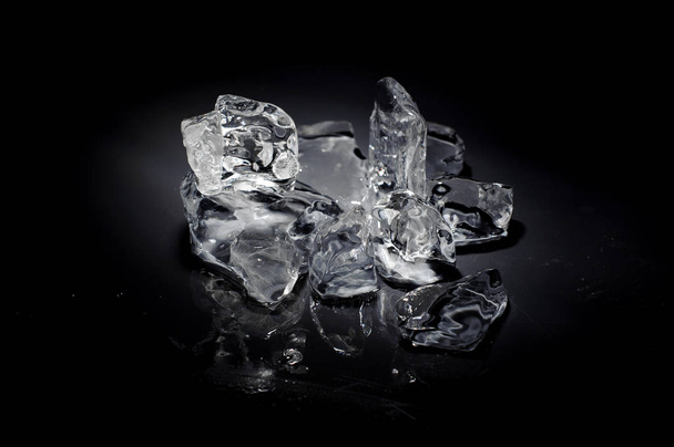 Top view of a stack of melting fresh ice cubes arranged on black background of studio - Φωτογραφία, εικόνα