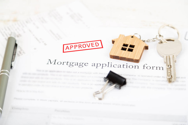 Approved mortgage loan agreement application with a house shaped keyring - Photo, Image