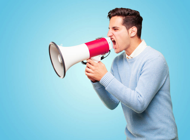 young handsome tanned man with a megaphone - Фото, изображение
