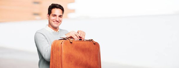 young handsome tanned man with a leather case luggage - Фото, изображение