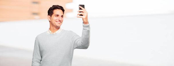 young handsome tanned man with a smart touch screen telephone - Photo, image