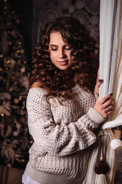 Pretty young woman in a room with christmas decoration. Winter mood, cozy home, scandinavian style - Foto, afbeelding