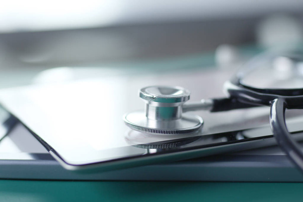 Medical equipment: blue stethoscope and tablet on white background. Medical equipment - 写真・画像
