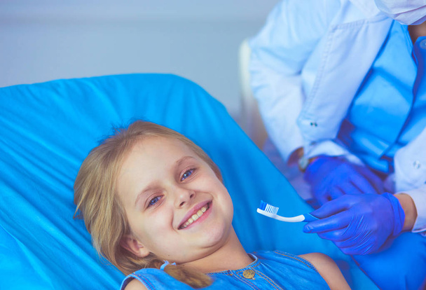 Little girl sitting in the dentists office. - Foto, Bild