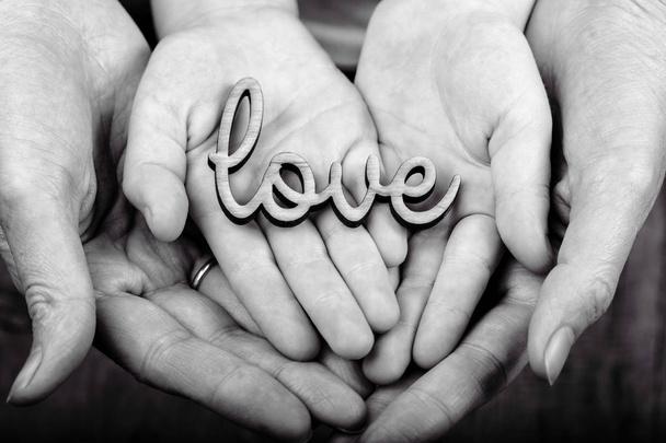 έννοια των οικογενειακών αξιών - χέρια που κρατούν την λέξη lov - Φωτογραφία, εικόνα