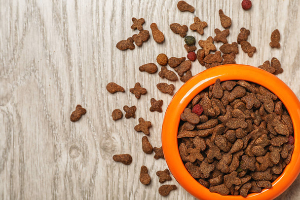 Bowl with food for cat or dog on wooden background. Pet care - Fotografie, Obrázek