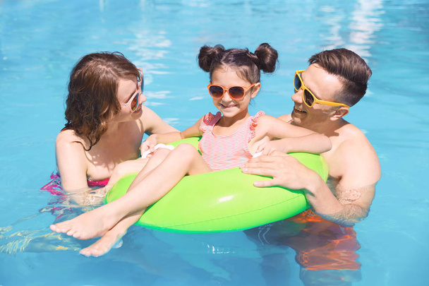 Familia feliz en la piscina en el complejo
 - Foto, imagen