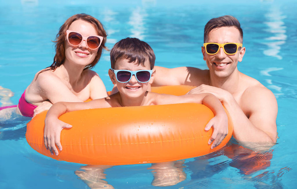 Happy family in swimming pool at resort - Foto, afbeelding