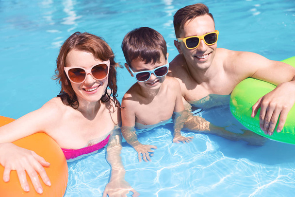 Happy family in swimming pool at resort - 写真・画像