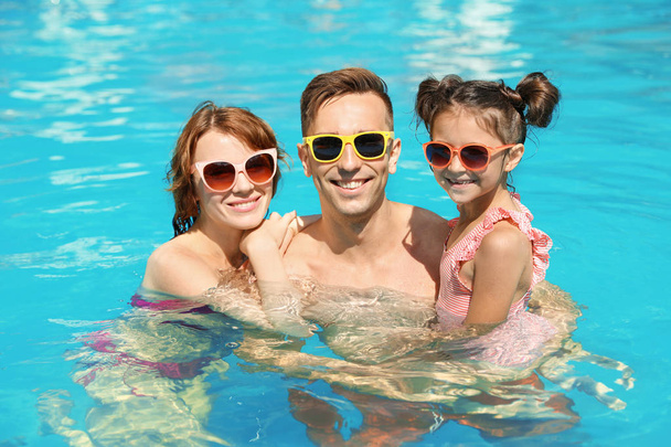 Happy family in swimming pool at resort - Фото, изображение