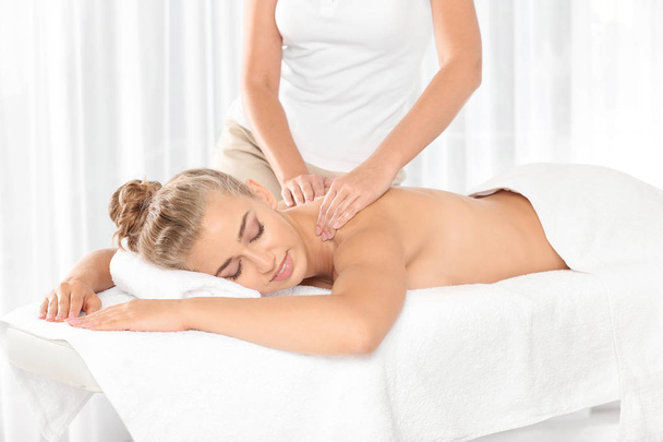 Relaxed woman receiving back massage in wellness center - Foto, Imagen