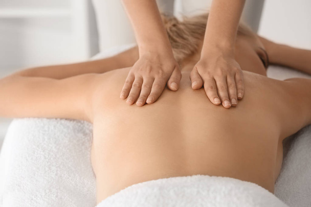 Relaxed woman receiving back massage in wellness center - Foto, imagen