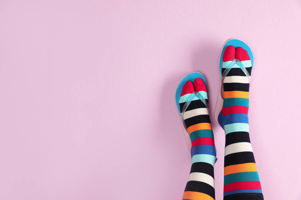 Woman wearing bright socks with flip-flops and space for design on color background - Fotoğraf, Görsel