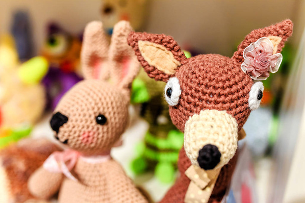 Různé pletené zvířata hračky na poličce doma, nebo k prodeji za baby shop - Fotografie, Obrázek
