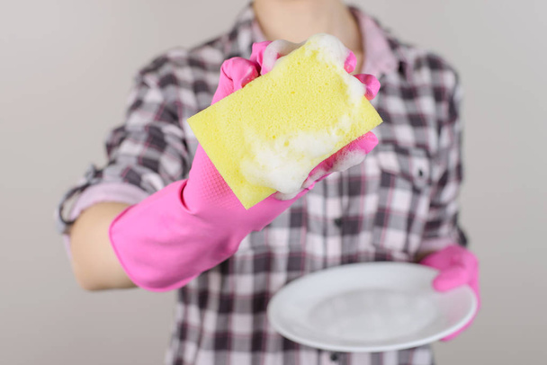 Yellow white shiny person family people clear cloth rag routine unhealthy care health concept. Close up photo of woman's hand demonstrating yellow sponge with foam isolated on gray background - Фото, изображение