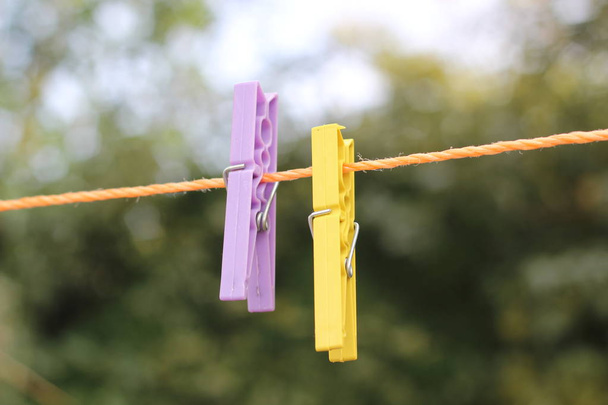 Detail schießen bunte Wäscheklammern auf Seil mit grünem Hintergrund aufgehängt - Foto, Bild