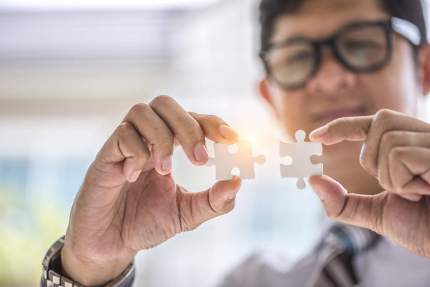 hand connecting jigsaw puzzle with sunlight affect, Business solutions, success and strategy concept - Foto, Imagen