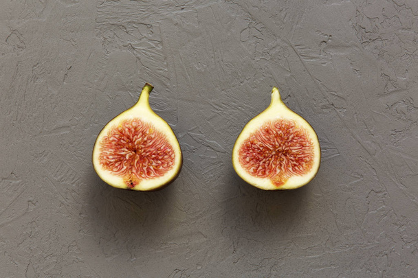 Two halves of a fig on concrete background, top view. Overhead, from above. - Foto, afbeelding