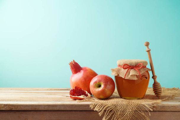 Jewish holiday Rosh Hashanah background with honey jar, apple and pomegranate on wooden table.  - Fotografie, Obrázek
