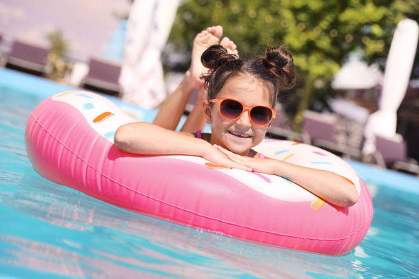 Little girl with inflatable ring in swimming pool - Photo, Image