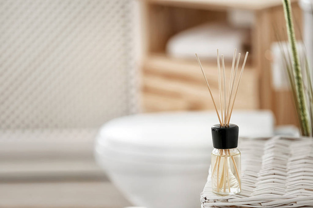 Aromatic reed air freshener on table against blurred background - Fotó, kép