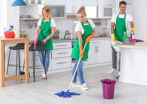 Team of professional janitors in uniform cleaning kitchen - Photo, image