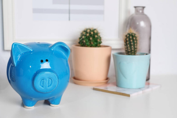 Color piggy bank on table in room. Cute interior element - Photo, Image