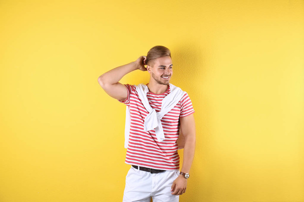Young man with trendy hairstyle on color background - Valokuva, kuva