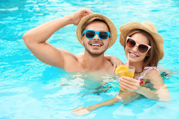 Young couple in pool on sunny day - Foto, immagini