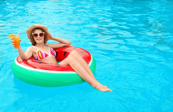 Mujer joven con cóctel en la piscina en un día soleado
 - Foto, Imagen