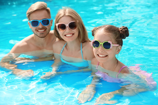 Happy family in pool on sunny day - Foto, afbeelding