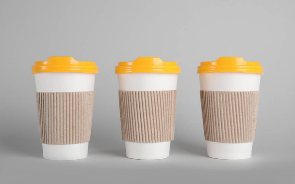 Carton cups on grey background. Mock up for design - Foto, afbeelding