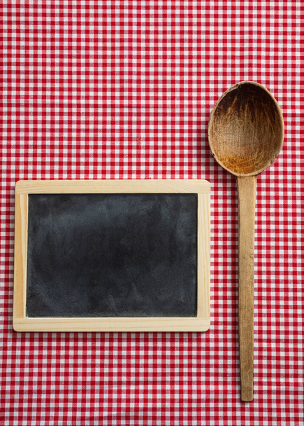 Menu concept. Blackboard and a wooden ladle on red checkered picnic tablecloth, space for text - Photo, Image