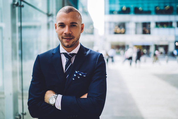 Portrait of confident successful entrepreneur dressed in formal wear looking at camera.Serious young businessman with crossed hands standing near office building.Prosperous proud ceo - Foto, Imagem
