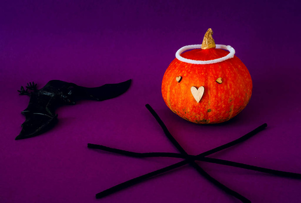Symbol of HALLOWEEN is Orange pumpkin, bat  and black spiderweb on purple background,copy space, closeup, - Photo, Image