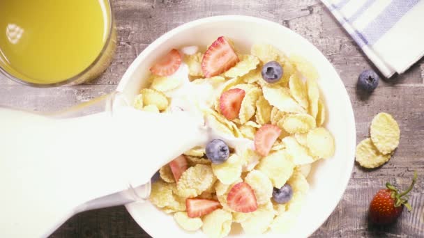 Slow motion corn flakes with berries pour liquid top view - Footage, Video