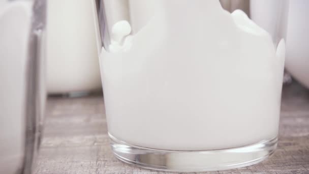 Lento movimiento la leche se vierte en un primer plano vaso
 - Metraje, vídeo