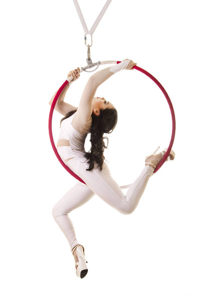 A young girl performs the acrobatic elements in the air ring. Studio shooting performances on a white background. - Photo, image
