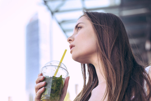 Model healthy food lips hungry energy hot sun day weather concept. Low angle side profile turned half close up portrait of beautiful pretty pensive lady holding glass of fresh beverage with fruit - Photo, Image