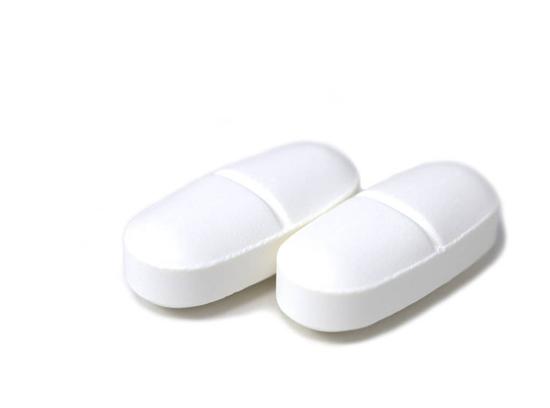 Close-up of two pills isolated on a white background - Photo, Image