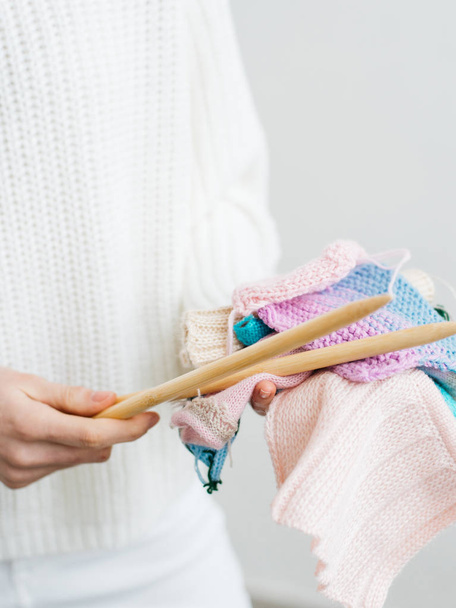 Pretty young woman knits woolen clothes. Girl with knitting needles and wool yarn - Foto, imagen