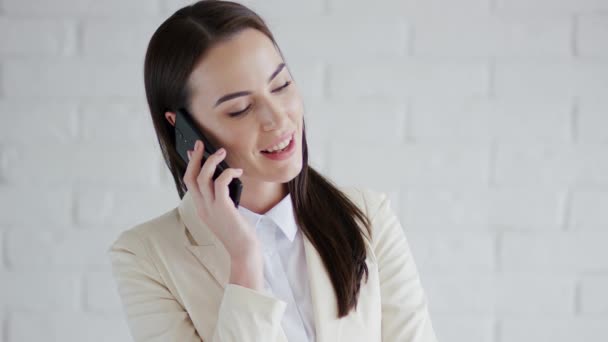 Smiling businesswoman speaking on phone - Кадры, видео