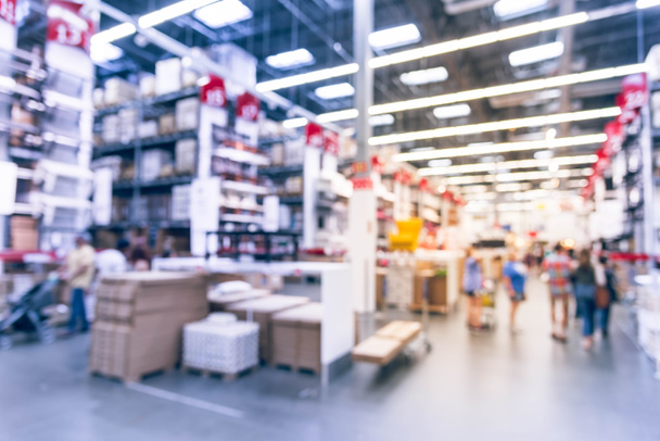 Blurred customers shopping in large furniture warehouse with row of aisles and bins from floor to ceiling. Defocused background industrial storehouse interior. Inventory, wholesale, logistic, export - Photo, Image