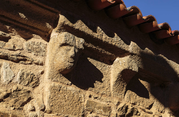 Détail de la corniche romane corbeau (cachorrada) avec une figure humaine sculptée dans la pierre de granit, dans le village historique de Castelo Rodrigo, Portugal
 - Photo, image