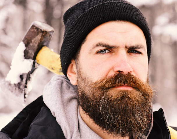 Man with beard holds ax. Guy with strict face - Zdjęcie, obraz