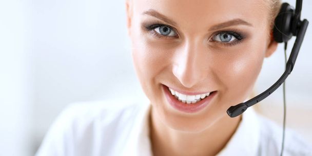 Close-up portrait of a customer service agent sitting at office - Foto, immagini