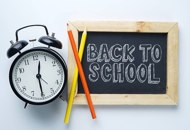 Back to School Text. Alarm Clock, Color Pencil and Blackboard on White Background - Foto, afbeelding