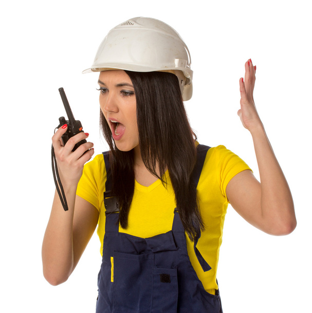 Serious female construction worker talking with a walkie talkie - 写真・画像
